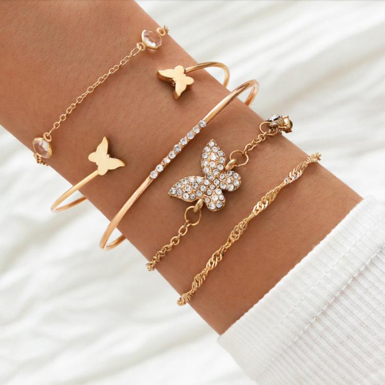 Gold butterfly charm crystal bracelet set with open cuffs and layered chain bangles