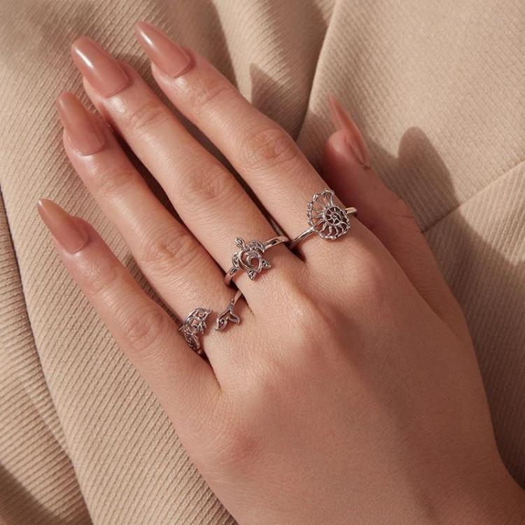 Three ocean-life adjustable open cuff rings on fingers, silver-tone with turtle motifs