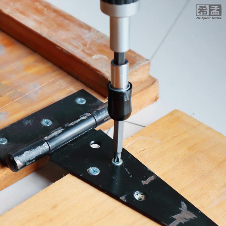 Screwdriver bit set in use driving screws into wood with a bit adapter
