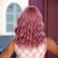 Back view of shoulder-length synthetic curly wig with bangs, smoky pink waves