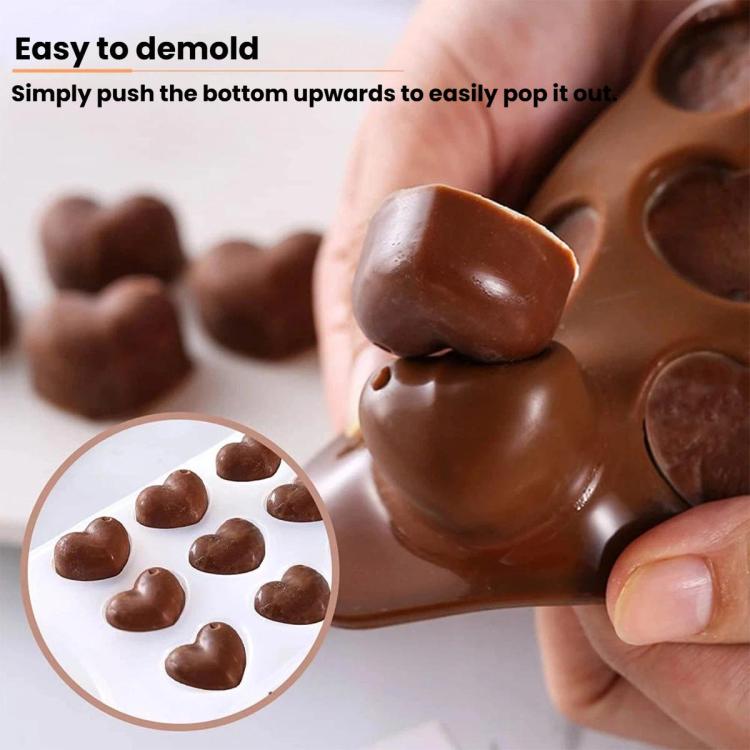 Brown silicone heart chocolate mold with hand pushing out molded chocolate hearts