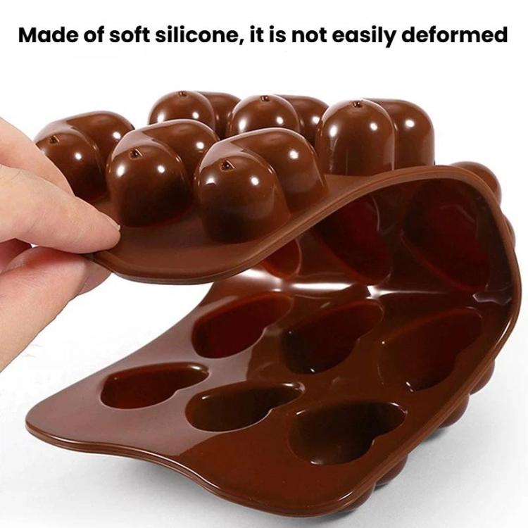 Brown silicone heart chocolate mold tray holding glossy chocolate hearts