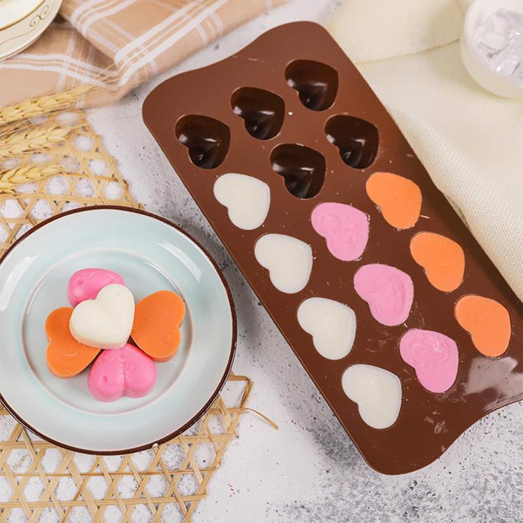 Brown silicone heart chocolate mold with filled hearts in white, pink, and orange