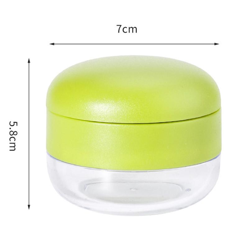 Green and clear manual garlic press, 7 cm width and 5.8 cm height.