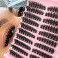 Curled dark segmented false eyelash clusters on adhesive strip, thick curled style