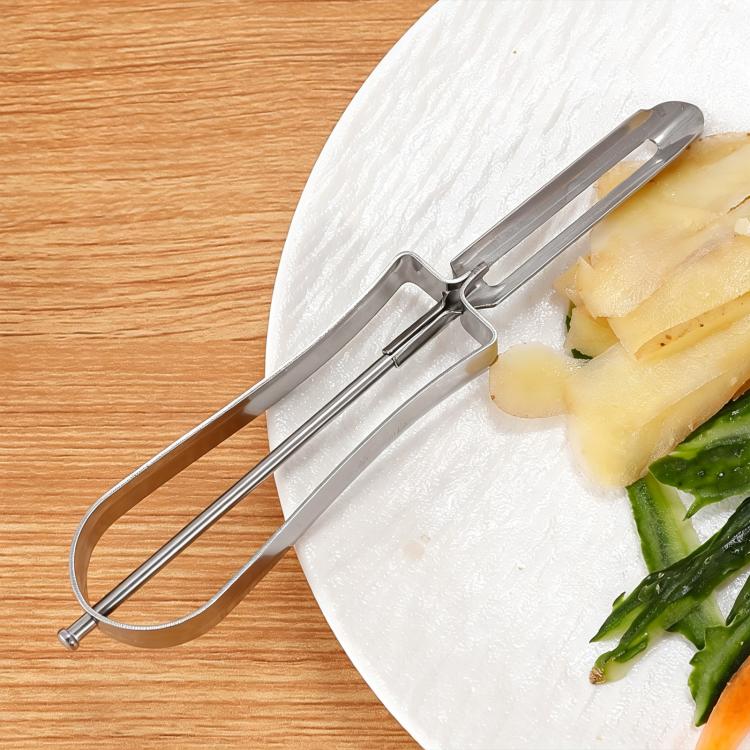 Stainless steel fruit peeler with U-shaped blade, peeling pineapple.