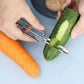 Vegetable peeler cutting wide peels from zucchini and carrot on a tray.