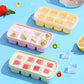 Three TPE ice cube mold trays in pastel colors, filled with fruit ice pieces