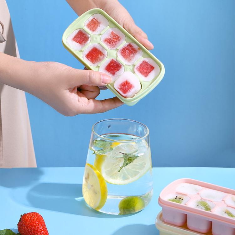Hands holding a mint-green TPE ice cube and jelly mold tray with fruit cubes