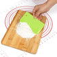 Plastic dough scraper with lime green blade used to spread flour on board