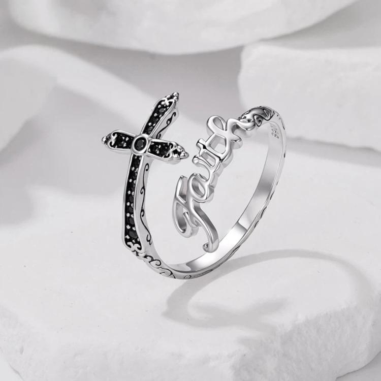 Side view of silver-tone adjustable cross ring with black stone inlay and Faith lettering