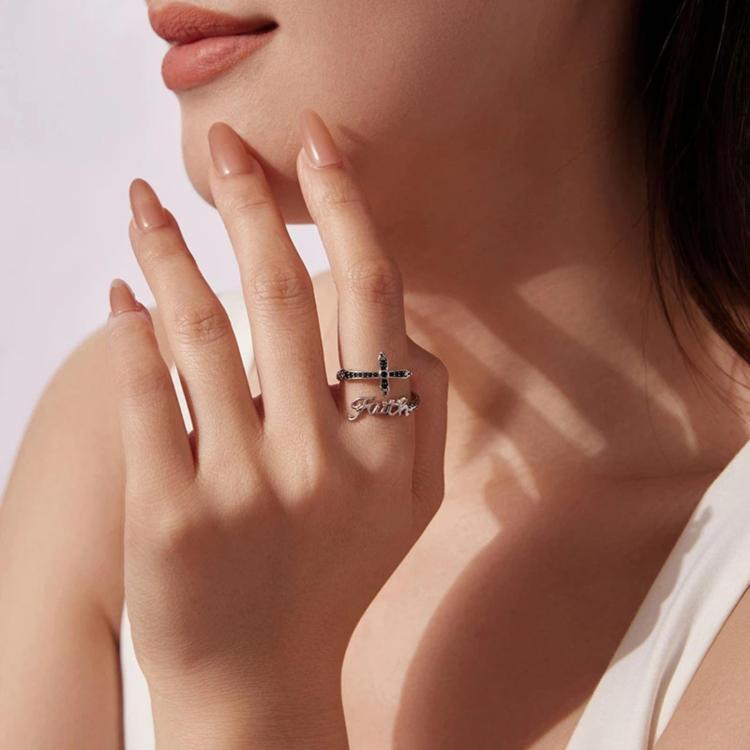 Woman wearing silver-tone adjustable cross ring with black stones and Faith lettering