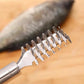 Close-up of stainless steel fish scaler teeth and square scraping head