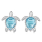 Silver-tone turtle stud earrings with blue gemstone and decorative side details
