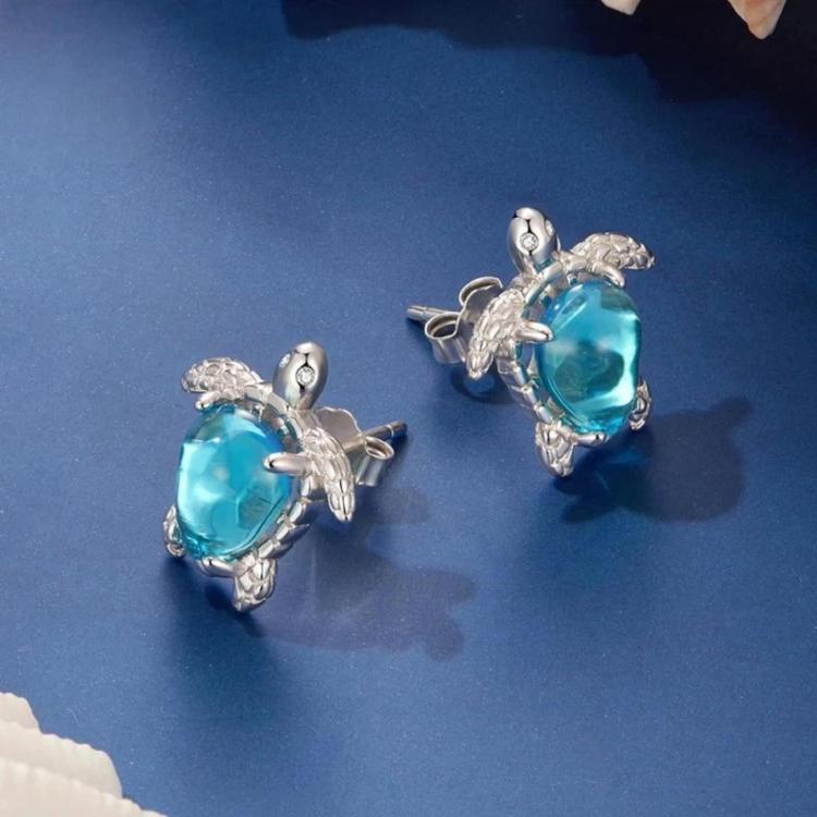 Silver-tone turtle stud earrings with blue gemstone, textured border and hinged backs