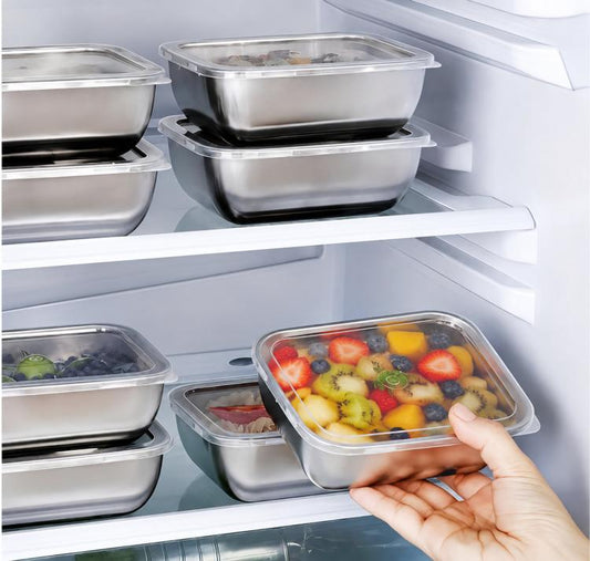Stainless steel food storage containers with clear lids, one held with mixed food inside