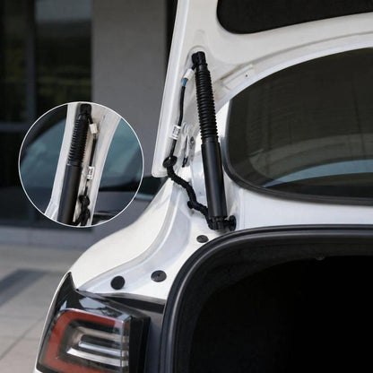 Electric trunk lift support strut with black spring boot, mounted on tailgate