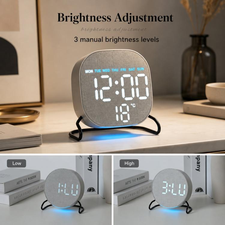 Round LED desk clock with gray fabric face and adjustable brightness, glowing time and temperature