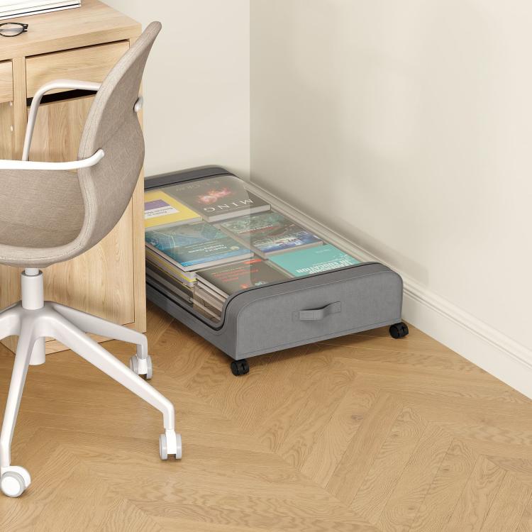 Gray underbed storage container with clear lid and rolling wheels beside desk chair