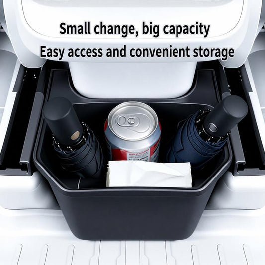 Rear seat storage box holding drinks and items in the open compartment, dark