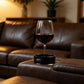 Black cup holder insert holding a stem wine glass on a sofa