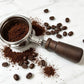 Walnut wood portafilter handle lying next to coffee grounds and beans