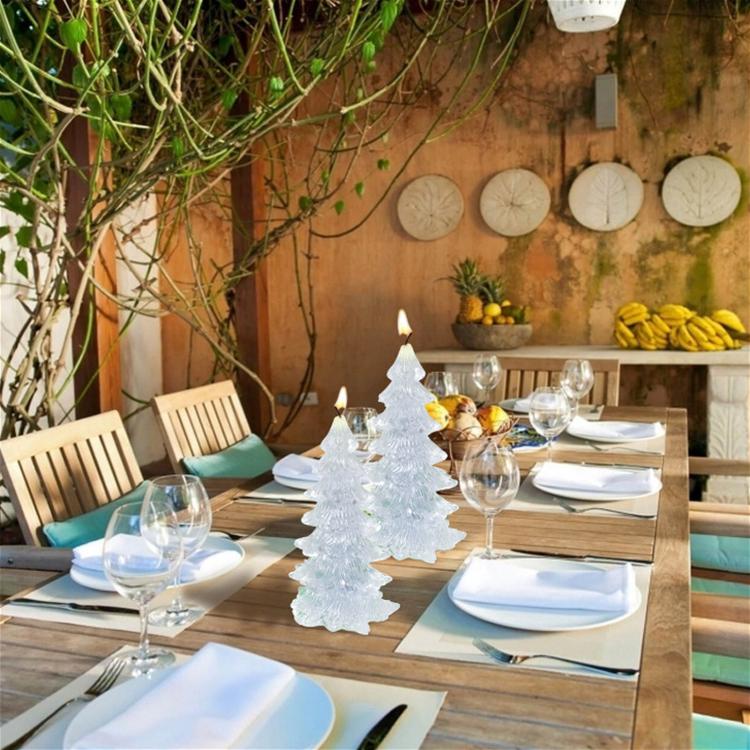 White Christmas tree shaped candles made from silicone tree molds on a dining table