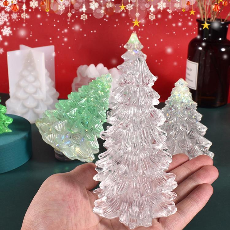Clear Christmas tree shaped candles made from silicone tree molds on red backdrop