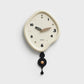 Beige irregular pendulum wall clock with off-white dial and dark pendulum weights