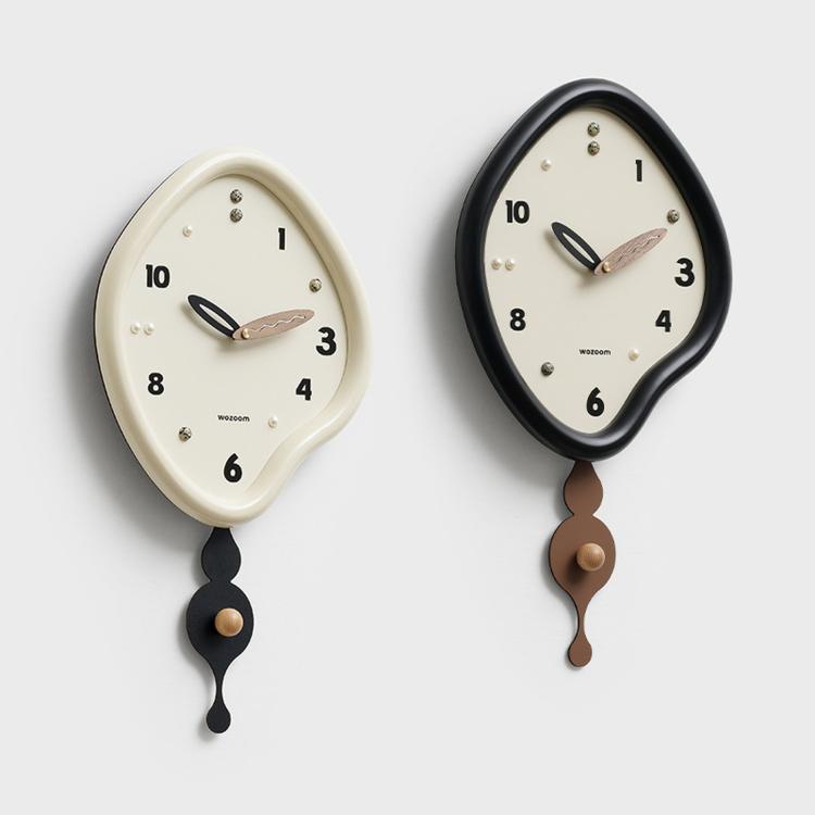 Set of irregular pendulum wall clocks in beige and black with pendulum weights
