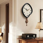 Wall-mounted black irregular pendulum clock with cream dial and bronze-brown pendulum