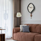 Black irregular wall clock with pendulum, white dial and gold hour markers