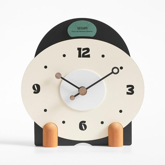 Small mantel table clock with cream face, black frame, and orange side pegs
