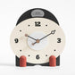 Small mantel table clock with cream face, black frame, and red side pegs