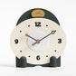 Small mantel table clock with cream dial, dark green top, and gray side pegs