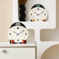 Two small mantel table clocks with cream dials, colorful side pegs