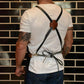 Black waterproof BBQ apron with cross-back straps and waist tie, worn on a model