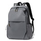 Slim gray laptop backpack with front flap, zip pockets, and padded shoulder straps.