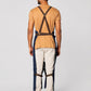 Denim split-leg work apron back view with X-back straps and tie waist.