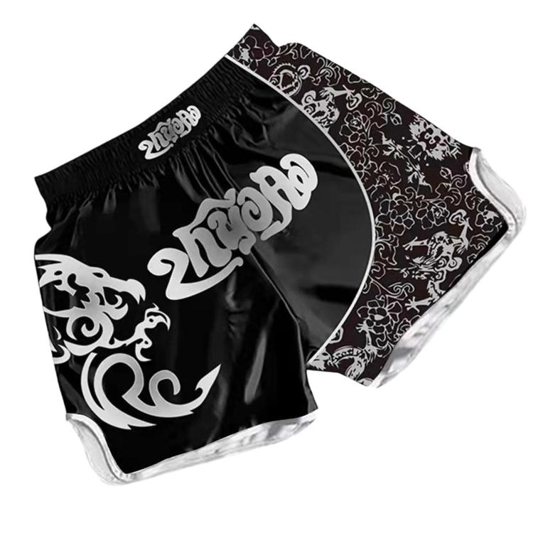 Muay Thai boxing shorts in black with white swirl graphic and floral-pattern side panel.