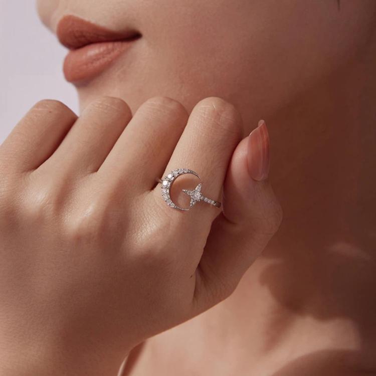 Sterling silver star motif adjustable ring on hand with round center moissanite