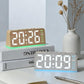 Digital alarm clock in light wood case with orange digits and green bottom ambient glow