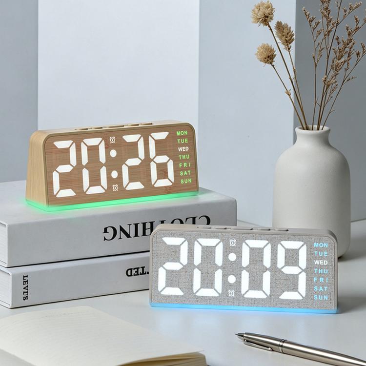 Digital alarm clock in light wood case with orange digits and green bottom ambient glow