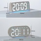 Digital alarm clock with textured grey case, large LED time/date digits and blue glow