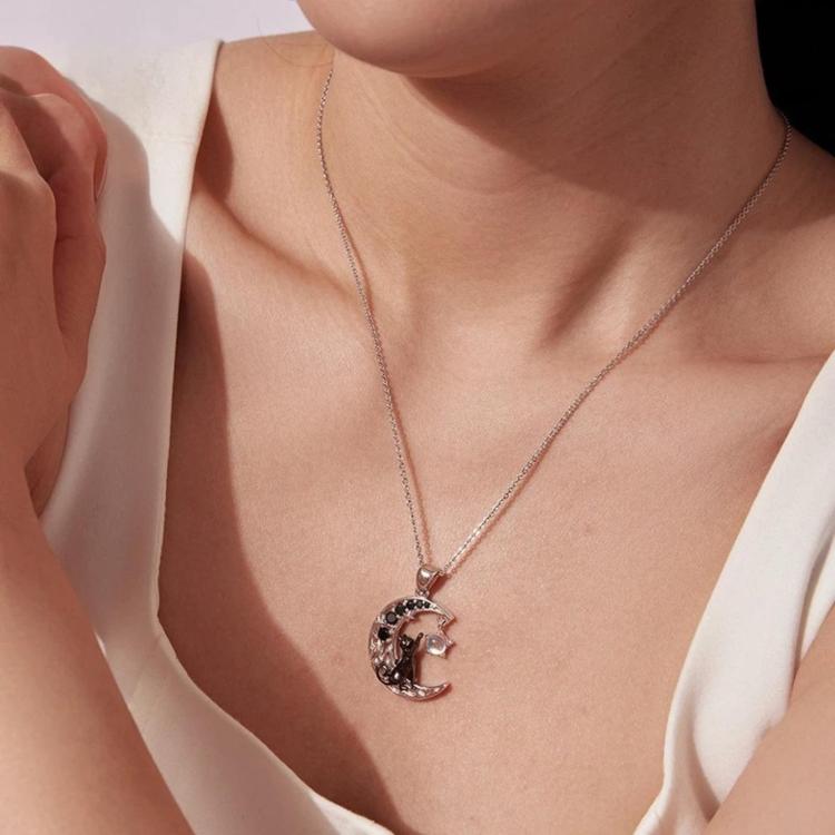 Moon cat pendant necklace worn on neckline with round pendant and blue moon accent