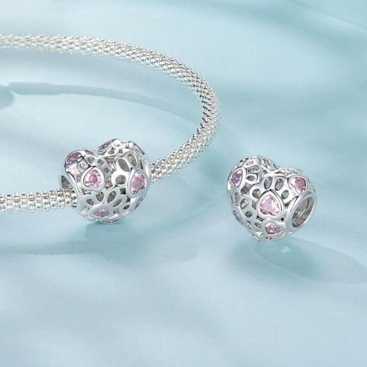 Heart-shaped charm bead with pink stones on a silver-tone bracelet chain