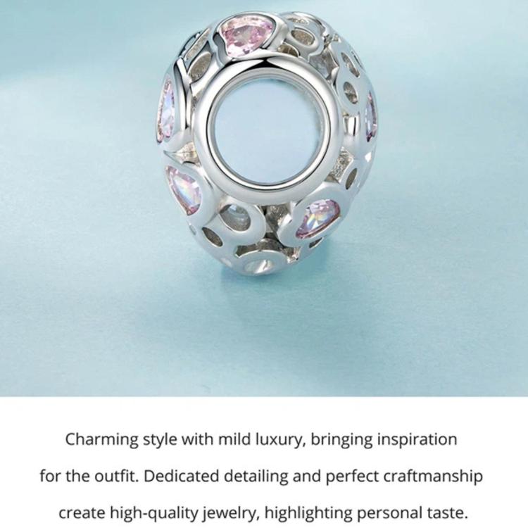 Heart-shaped openwork bead charm with pink stone accents, silver-tone metal