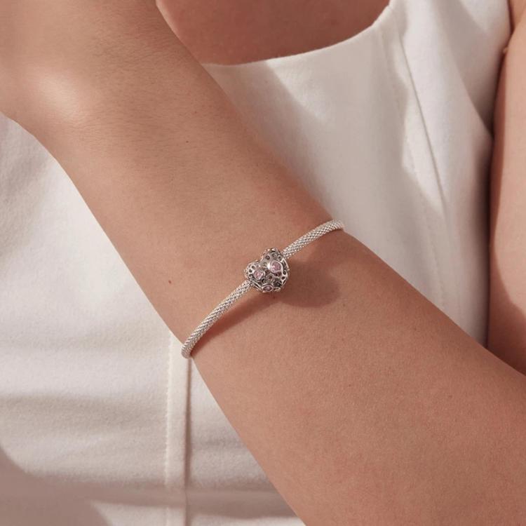 Silver-tone chain bracelet with heart charm bead and pink crystal worn on wrist