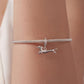 Running dachshund charm bracelet on wrist with mesh chain and crystal hoop, silver-tone