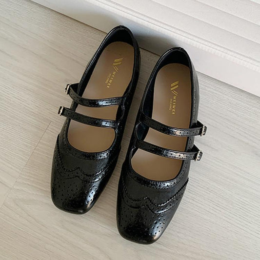 Black ballet flats with buckle straps and perforated detailing
